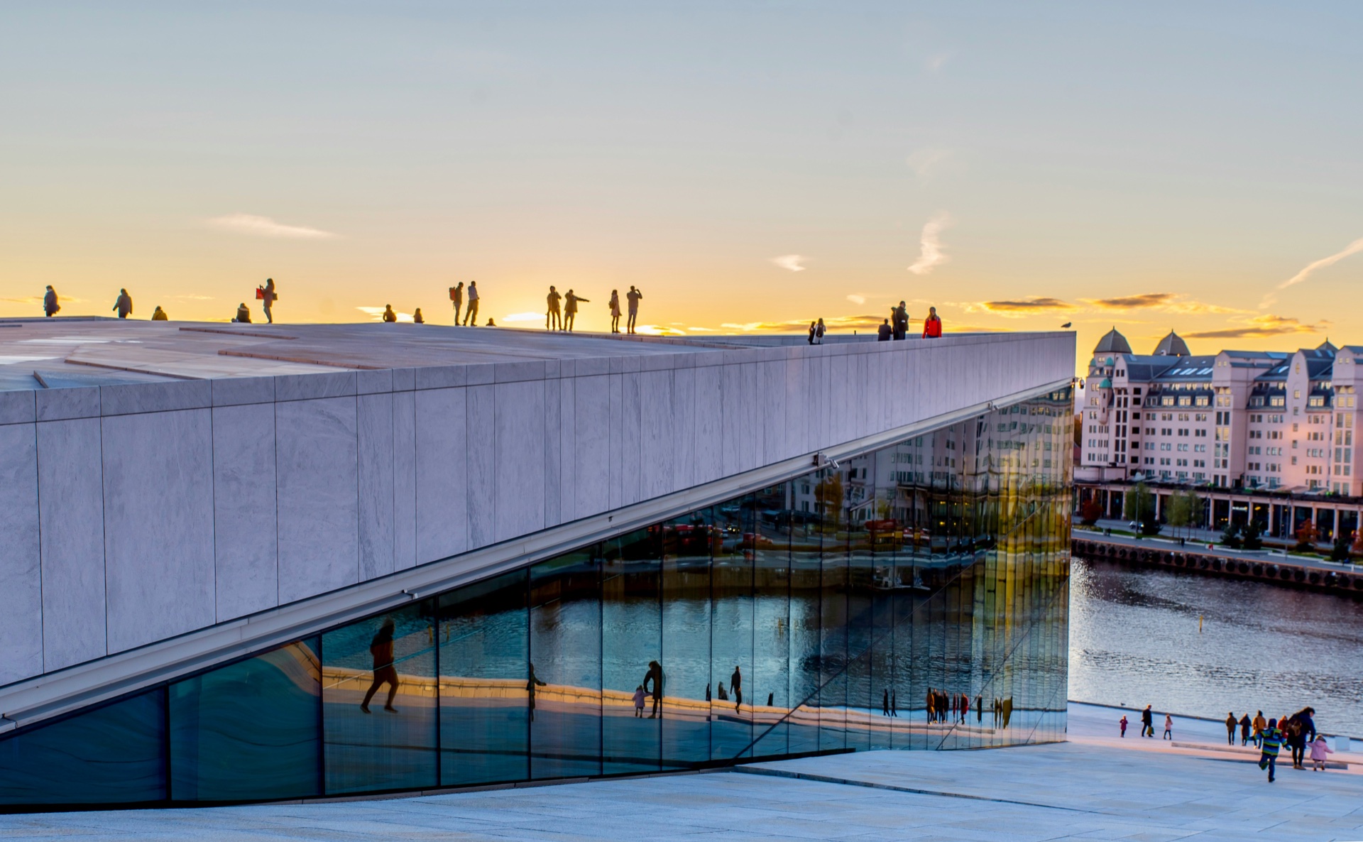 People walking on the Oslo Opera House roof at sunset