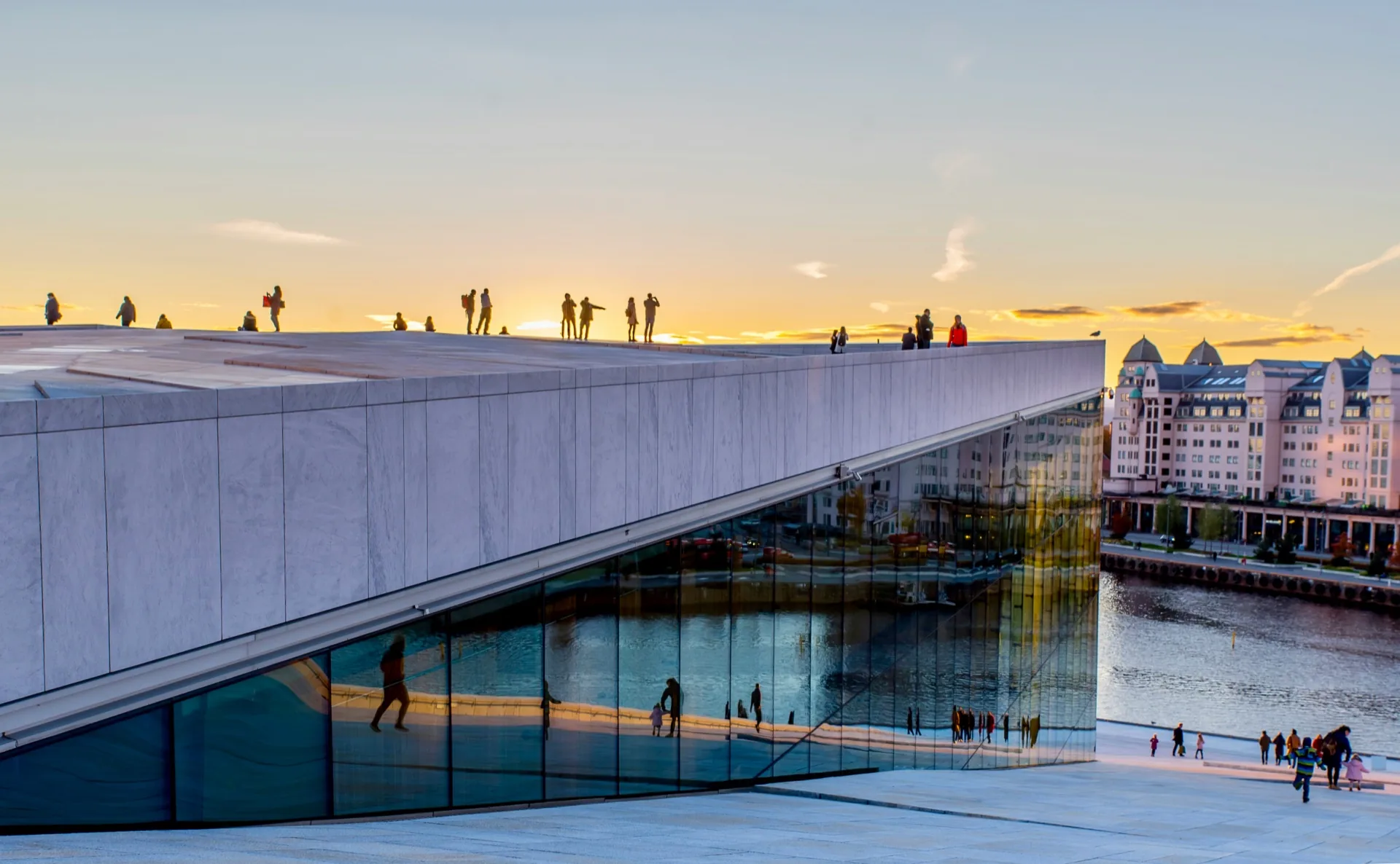 People walking on the Oslo Opera House roof at sunset