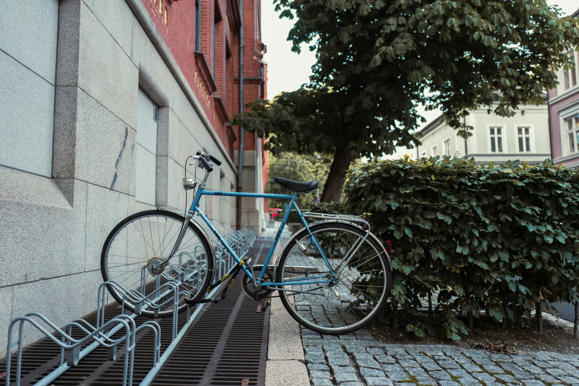 Blue bike on a cobbled Oslo street in summer